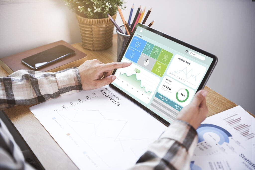 A man in an office studying an analysis and graphs his tablet