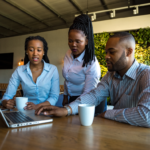 2 black women and black man in an office having a meeting